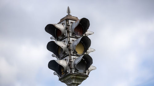 Low angle view of road signal against sky