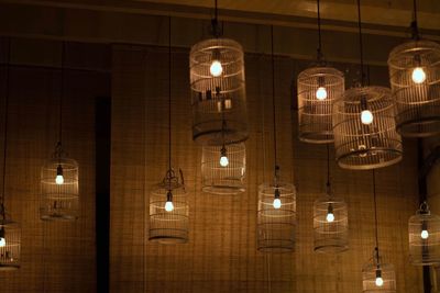 Low angle view of illuminated pendant lights hanging from ceiling