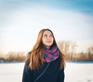 Thoughtful young woman standing outdoors during winter