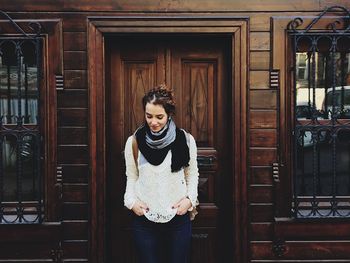 Portrait of young woman in front of wooden building