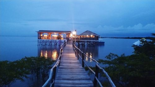 Pier over sea against sky at night