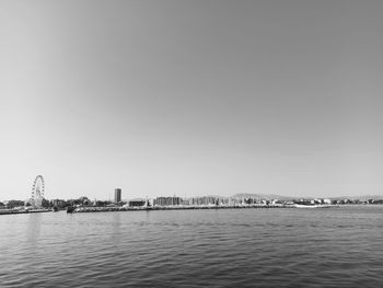 Scenic view of sea and buildings against clear sky