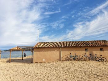 Lifeguard hut on beach by sea against sky