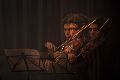 Young man holding guitar at music concert