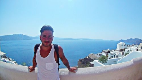 Portrait of young man standing in sea against clear sky