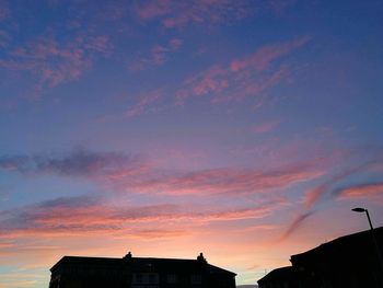 Low angle view of silhouette roof against sky during sunset