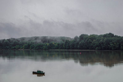 Boat sailing in lake against sky