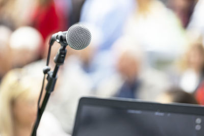 Microphone in focus against blurred audience. participants at the business conference.