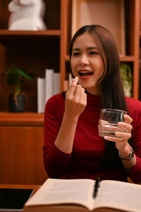 Young woman using mobile phone at table