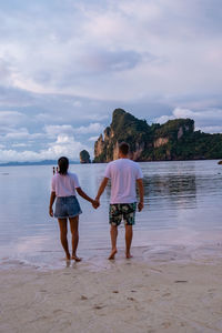 Rear view of women standing on beach