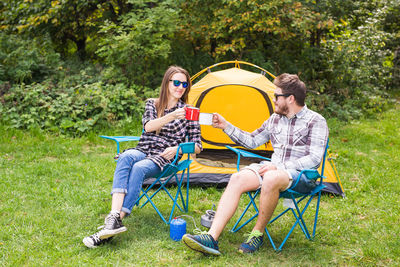 Full length of a young couple sitting on seat