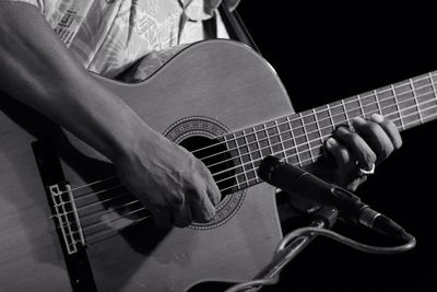 Midsection of man playing guitar