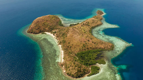 Tropical island with lagoons and coral reef, beach, in the blue and clear water. dinanglet