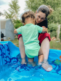 Rear view of mother and daughter in swimming pool