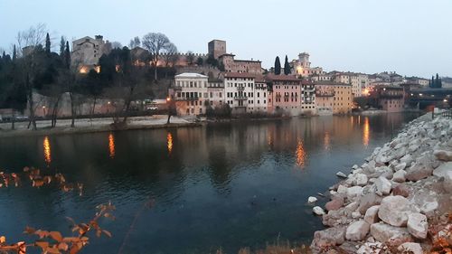 River by buildings against clear sky