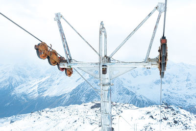 Close-up of the metal structure of the cable car on the background of snowy mountains. ski resort.