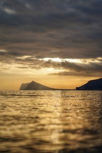 Scenic view of sea against dramatic sky during sunset