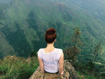 Rear view of woman on rock