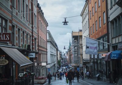 People on street in city against sky