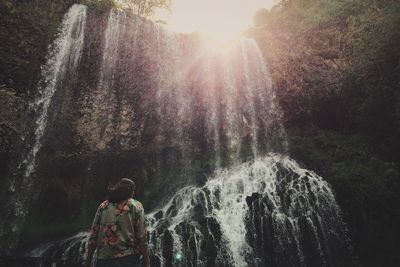 Rear view of woman overlooking waterfall