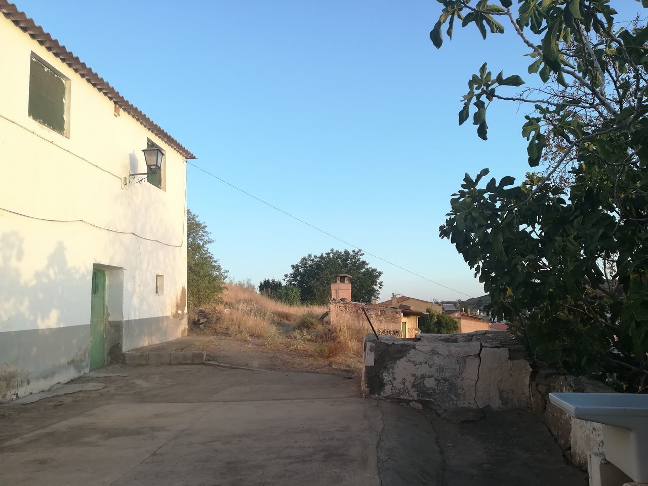 HOUSES BY ROAD AGAINST SKY IN CITY