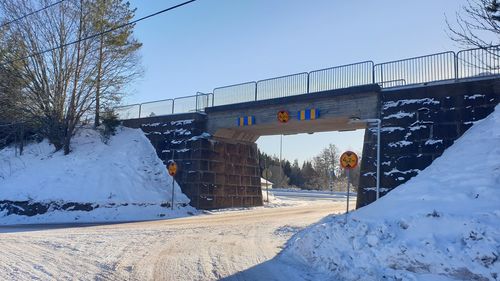 Bridge over road against clear sky during winter