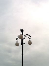 Low angle view of street light against cloudy sky