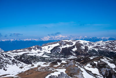 Scenic view of snowcapped mountains against blue sky