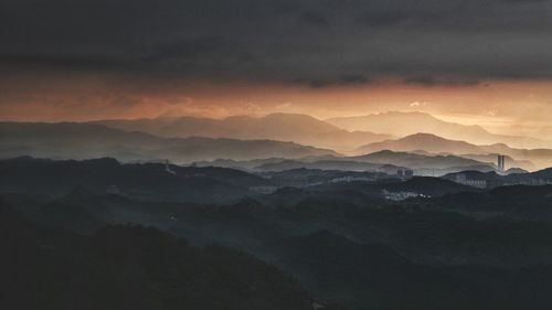 Scenic view of silhouette mountains against sky at sunset