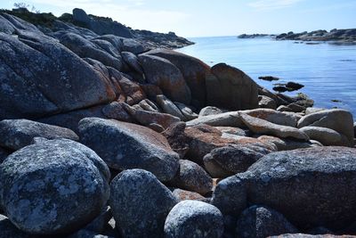 Rocks on beach against sky