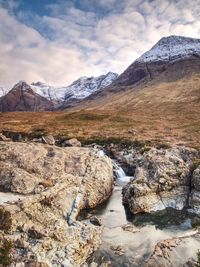 Waterfall and rapids against to scenic snowy mountain landscape, isle of skye, scotland