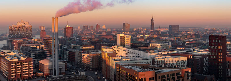 Aerial view of illuminated cityscape against sky during sunset