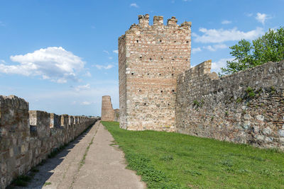 Stone wall of fort against sky