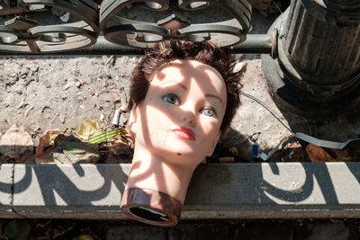 High angle view of female mannequin head on footpath