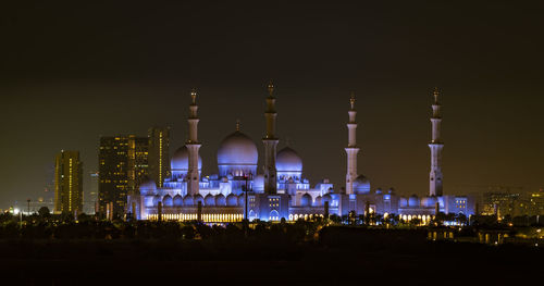 Illuminated buildings against sky at night