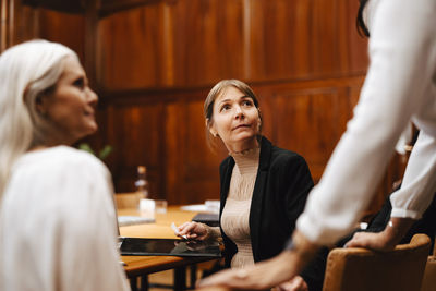 Female lawyers listening to colleague in meeting at office