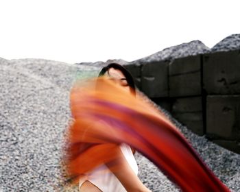 Blurred motion of young woman dancing outdoors
