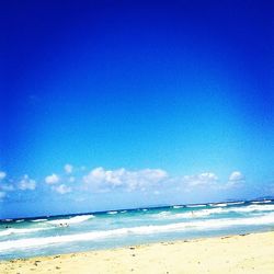 Scenic view of beach against blue sky