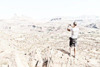 Rear view of man photographing
