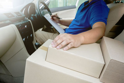 Midsection of delivery person sitting in car