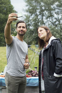 Mid adult couple taking selfie through mobile phone in urban garden