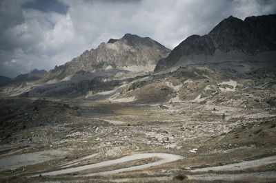 Scenic view of rocky mountains against cloudy sky