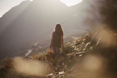 Rear view of woman walking on mountain