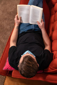 High angle view of man wearing mask reading book