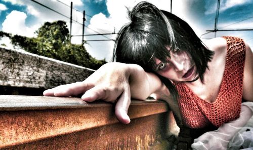 Young woman lying down while sitting on floor