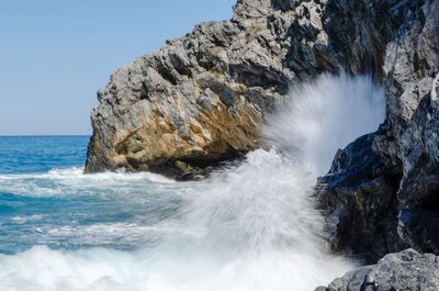 Scenic view of rocks in sea against sky