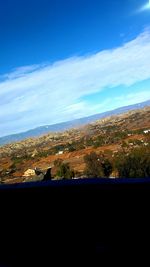 Scenic view of landscape against blue sky