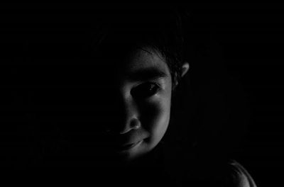 Portrait of serious young man against black background