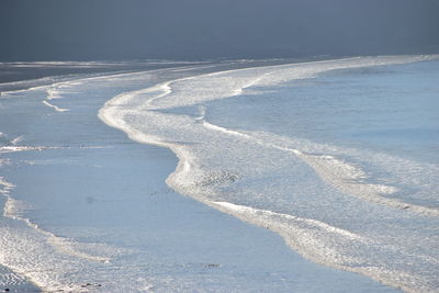 High angle view of waves on sand