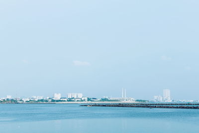 Sea by buildings against sky